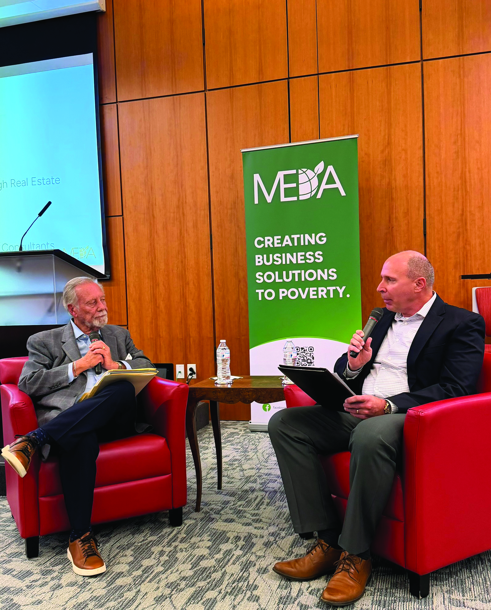 Two men speak at a MEDA Network event.